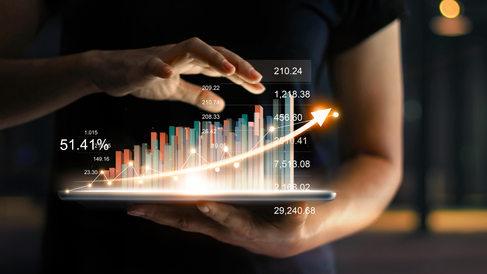 A person is holding a tablet with a graph about growth on it.