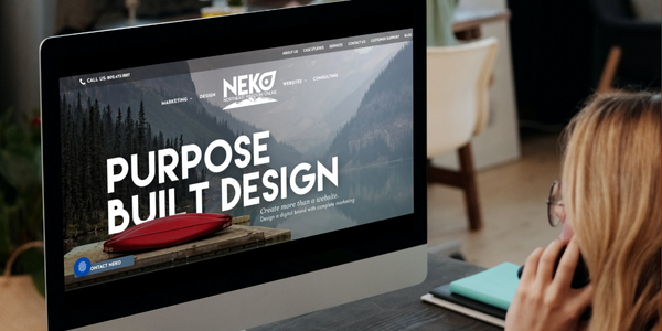 Computer screen displaying a website with cityscape background, pencils, and design tools.