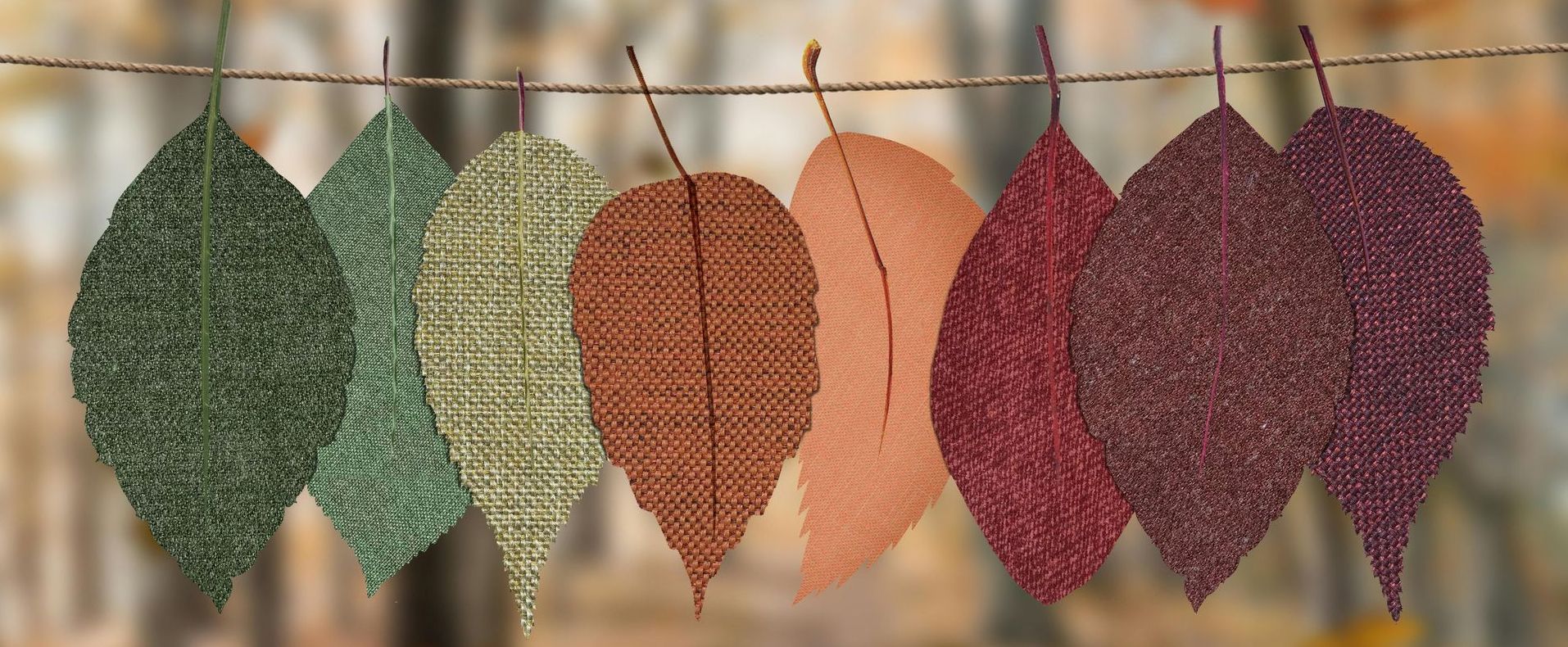 A row of leaves of different colors hanging on a string