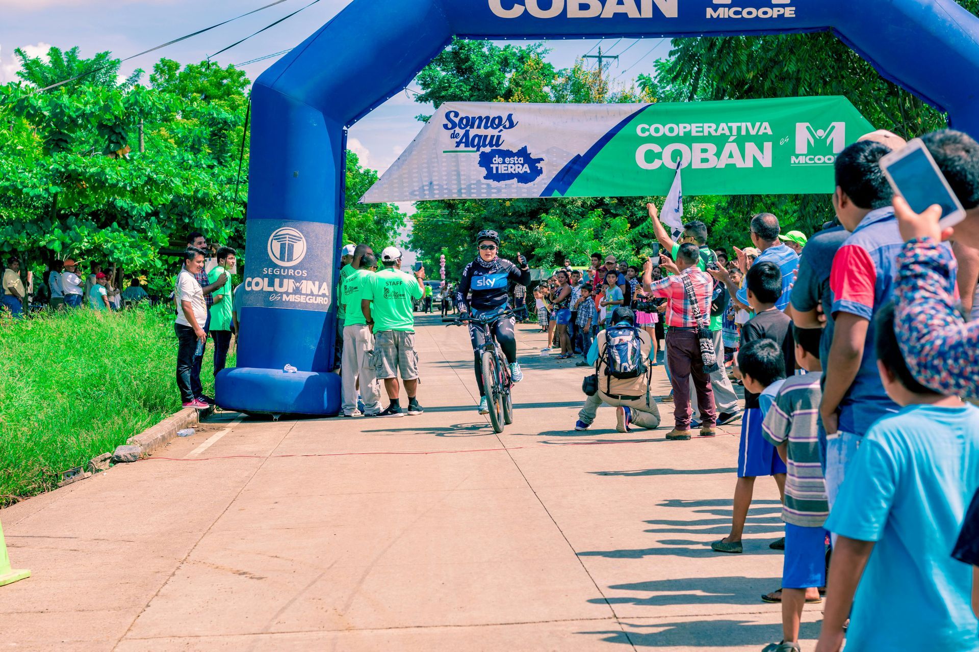 A person riding a bike at a large outdoor event