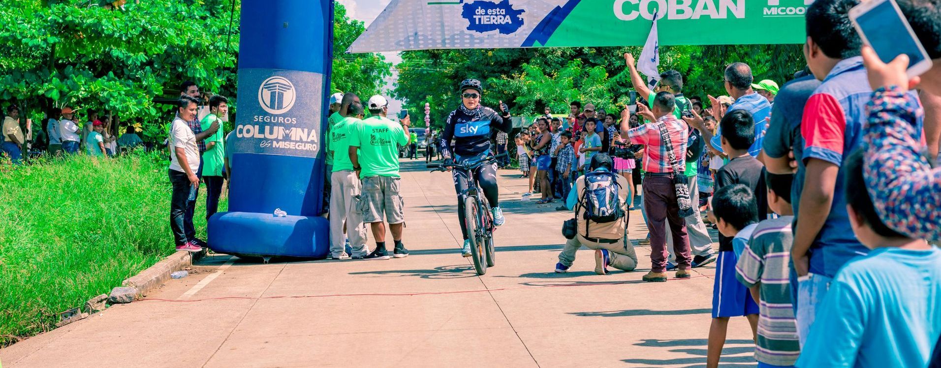 A group of people at an event are watching a person riding a bike