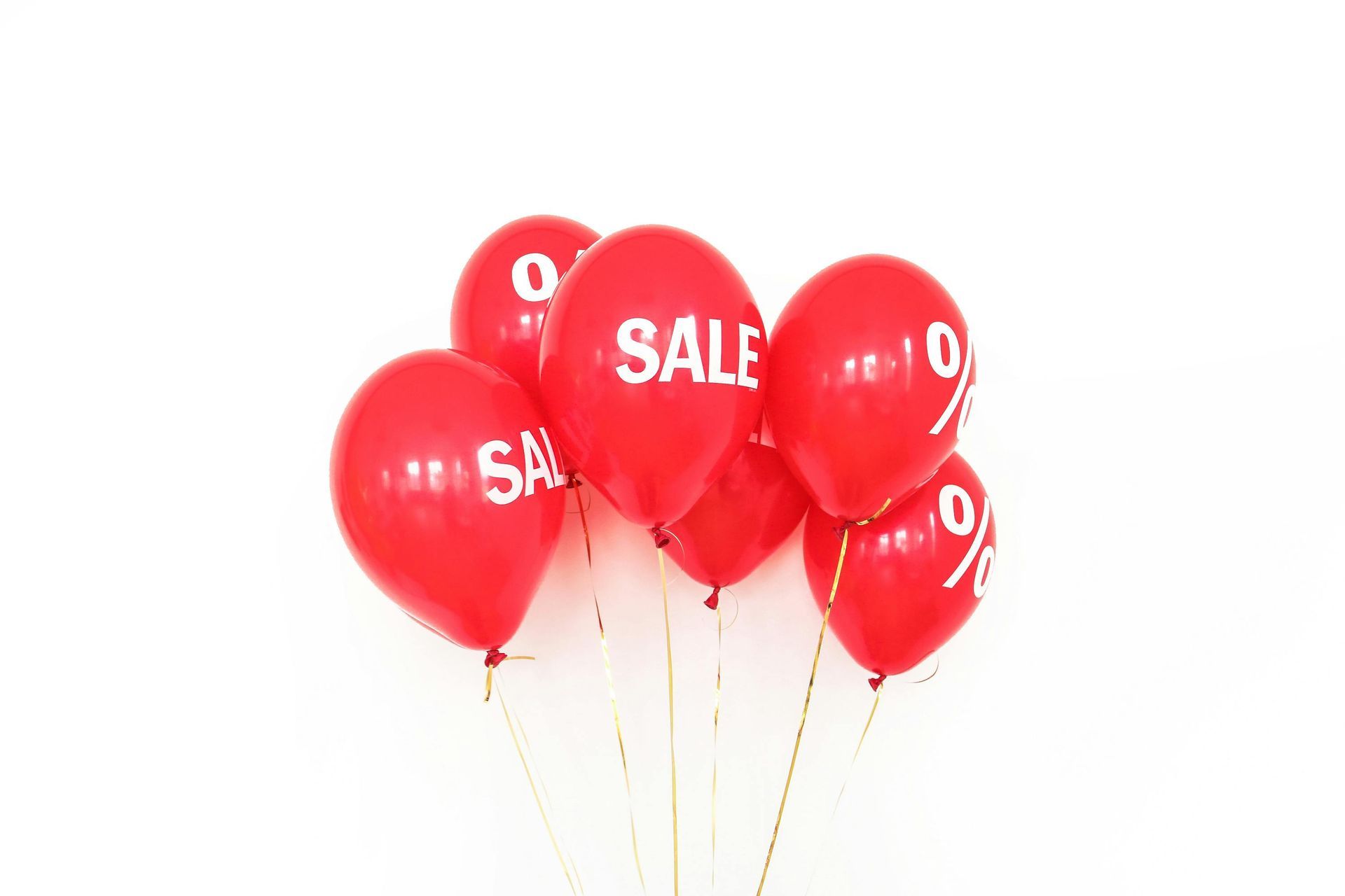 A bunch of red balloons with the word sale on them