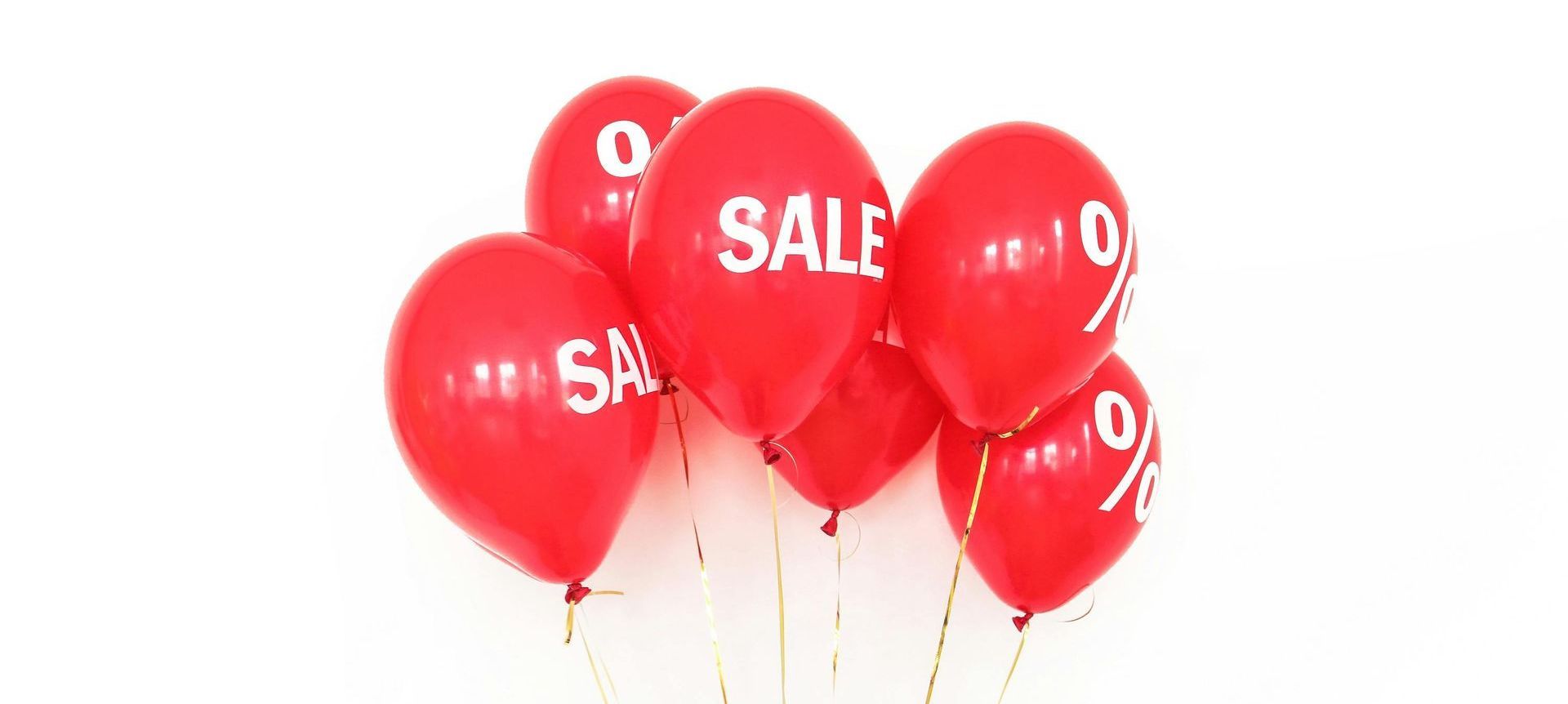 A bunch of red balloons with the word sale written on them