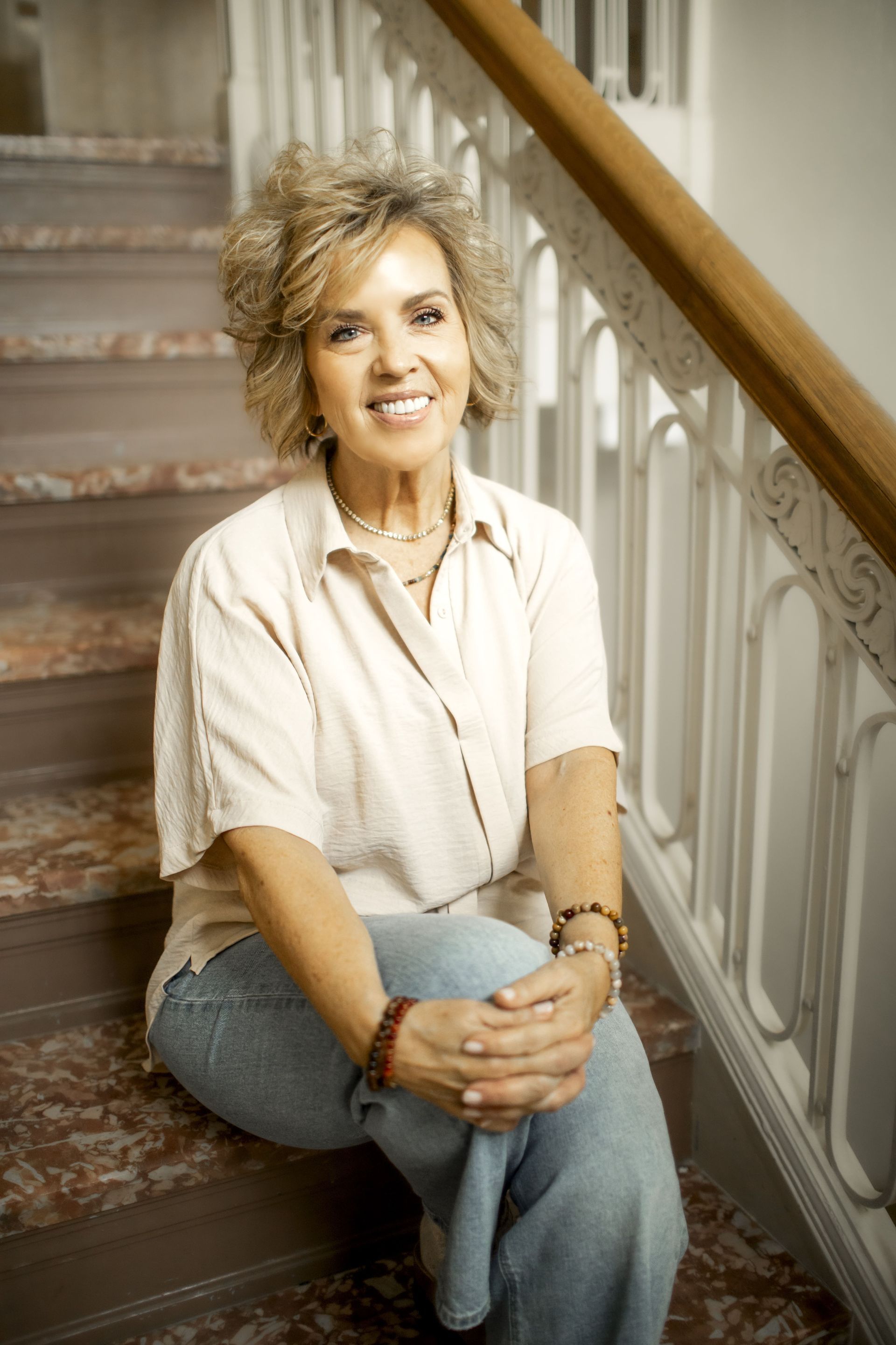 Woman with headache, touching head; sitting on couch. Red highlight indicates pain.