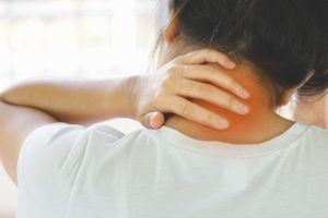 Woman holding her neck, appearing to be in pain. Red glow highlights painful area.