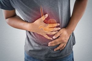 Man clutching abdomen, stomach illustration overlayed, indicating abdominal pain.