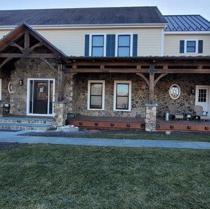 A large house with a large porch and a lot of windows.