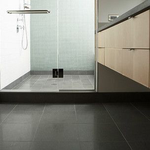 A bathroom with a walk in shower and a sink.