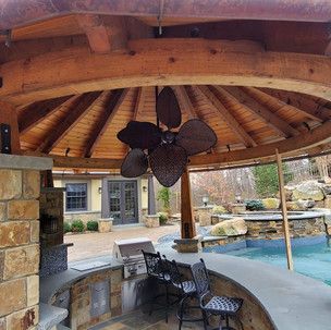 A ceiling fan is hanging from the ceiling of a gazebo.