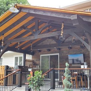 A covered patio with a wooden roof and a sliding glass door.