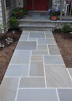 A stone walkway leading to the front door of a house.
