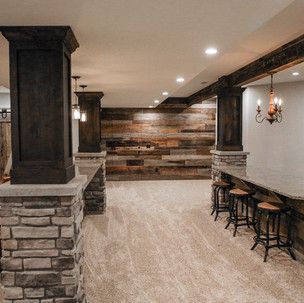 A basement with a wooden wall and a table and stools.