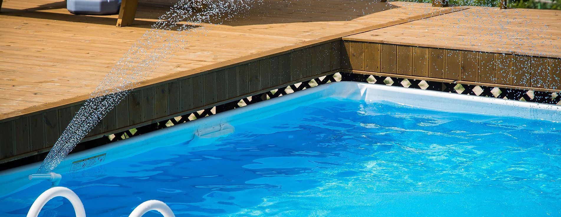 A swimming pool with a fountain in the middle of it