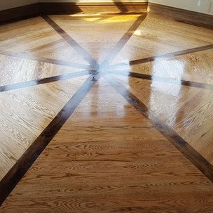 A close up of a wooden floor with a pattern on it.