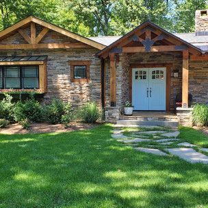 A stone house with a blue door and a walkway leading to it.