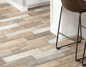 A bar stool is sitting next to a wooden floor in a kitchen.