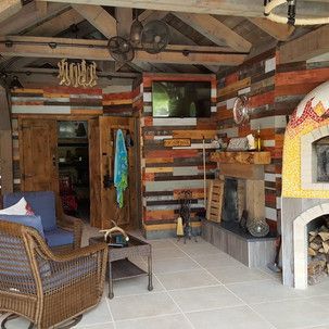 A living room with a fireplace , chairs , table and television.