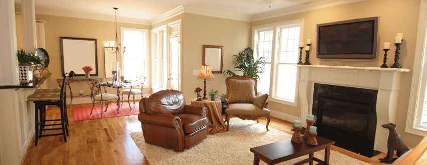 A living room with a fireplace and a television on the wall