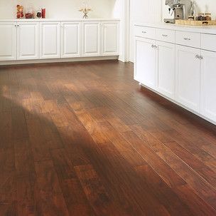 A kitchen with hardwood floors and white cabinets.