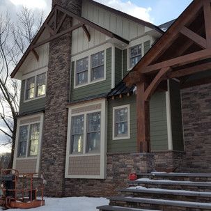 A large house with a lot of windows and stairs in the snow.