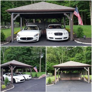 Two white cars are parked under a carport with an american flag.