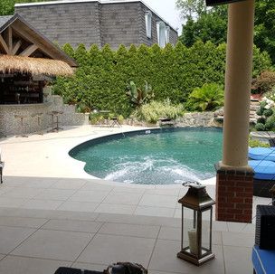 There is a large swimming pool in the backyard of a house.