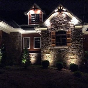 A large brick house is lit up at night.