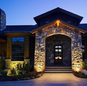 A large stone house is lit up at night.