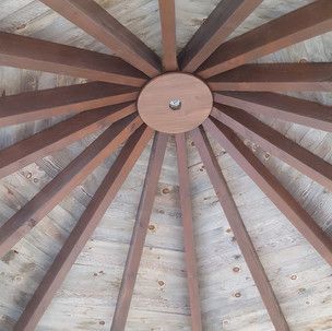 A close up of a wooden ceiling with a round hole in the middle.