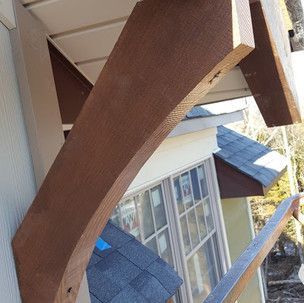 A wooden beam is attached to the side of a house.