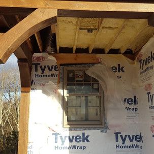A window is being installed on the side of a house.
