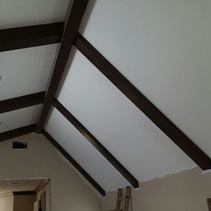 A living room with a vaulted ceiling and wooden beams.