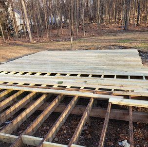 A wooden deck is being built in the middle of a forest.