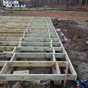 A wooden deck is being built in a dirt field.
