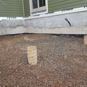 A pile of gravel is sitting in front of a house.
