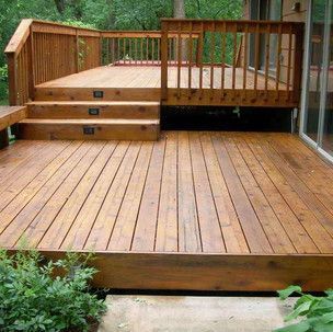 A large wooden deck with stairs and a railing.