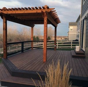 A wooden deck with a pergola on top of it.