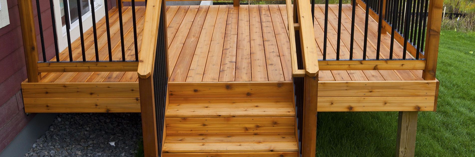 A wooden deck with stairs and a metal railing.