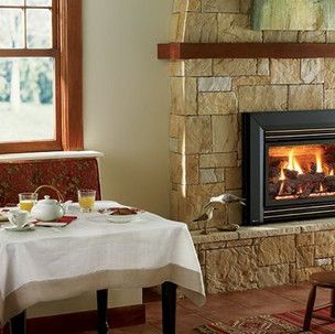 A dining room with a table and chairs and a fireplace.