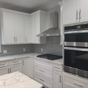 A kitchen with white cabinets and stainless steel appliances.
