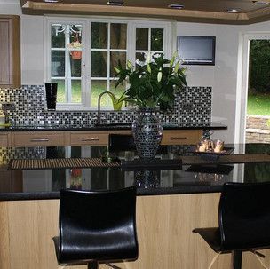 There is a vase of flowers on the counter in the kitchen.