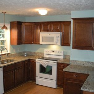 A kitchen with a stove a sink and a microwave