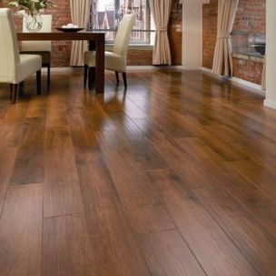 A dining room with a wooden floor and a table and chairs.