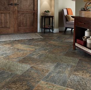 A living room with a slate floor and a wooden door.