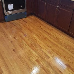A kitchen with hardwood floors , cabinets , and a stove.