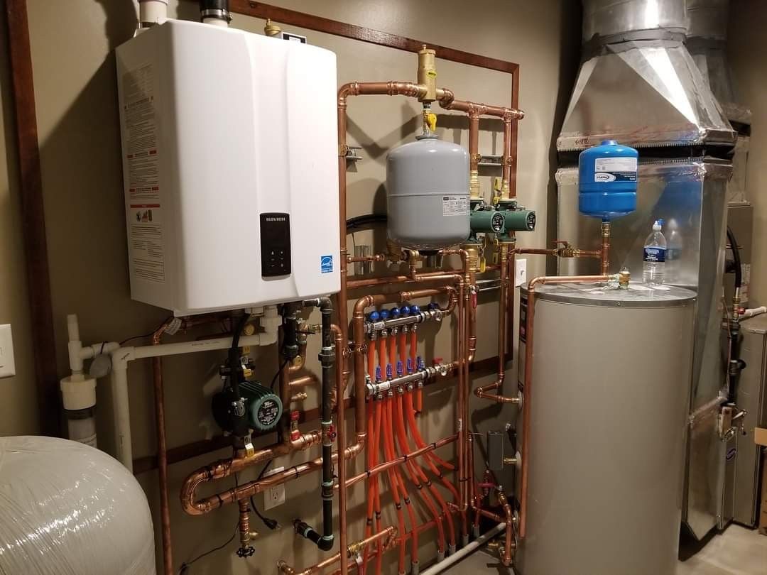 A room with a lot of pipes and a boiler.