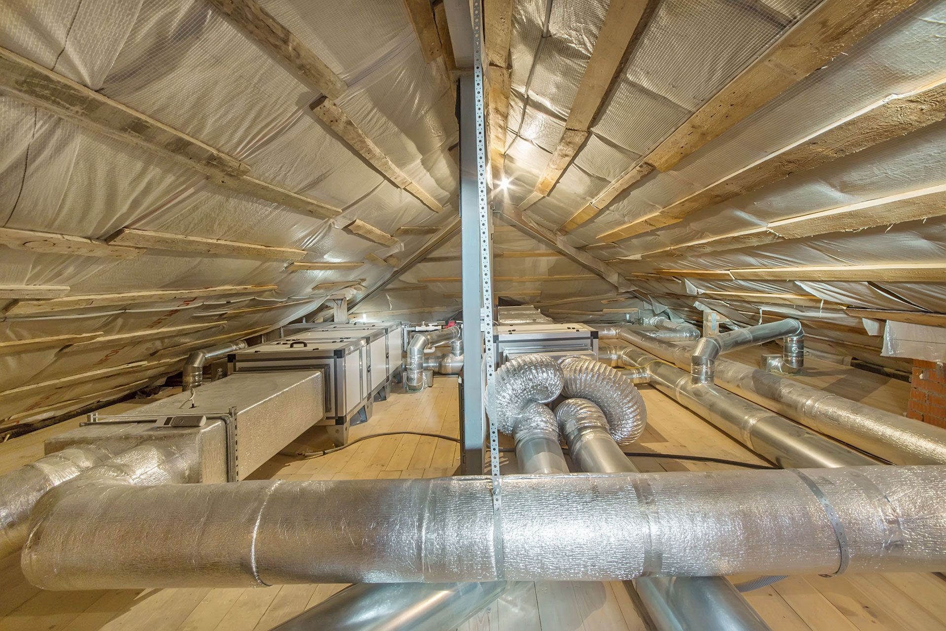 There are a lot of pipes in the attic of a house.
