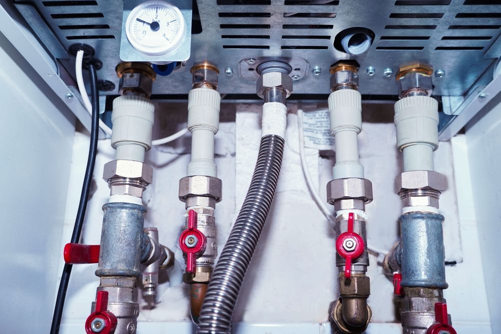 A room with a lot of pipes and a boiler.