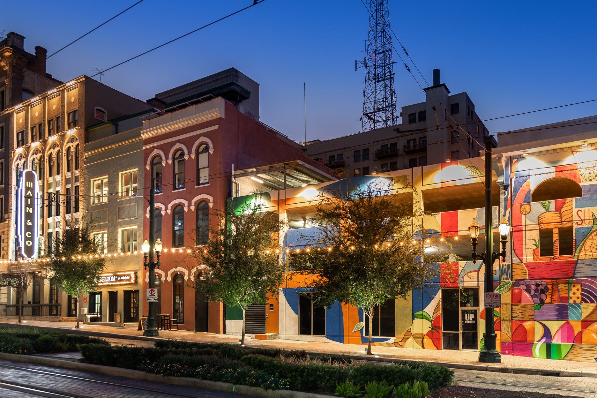 A row of buildings are lit up at night in a city.