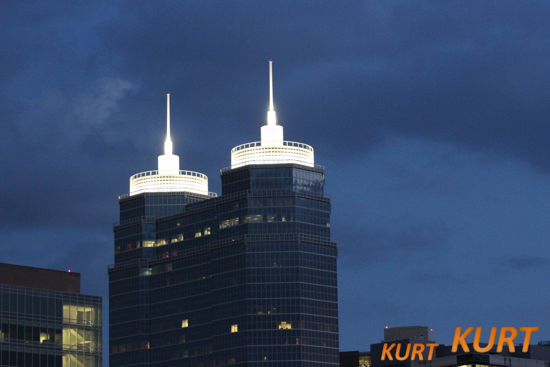 Two very tall buildings with the word kurt on the bottom right